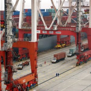 Containers being loaded onto a ship behind enormous crane gantrys at Yangshan deep water port