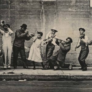 King Oliver's Band in New Orleans, ca. 1921. Ram Hall, Honore Dutrey, King Oliver, Lil Hardin, David Jones, Johnny Dodds, James Palao, & Ed Garland on the sidewalk